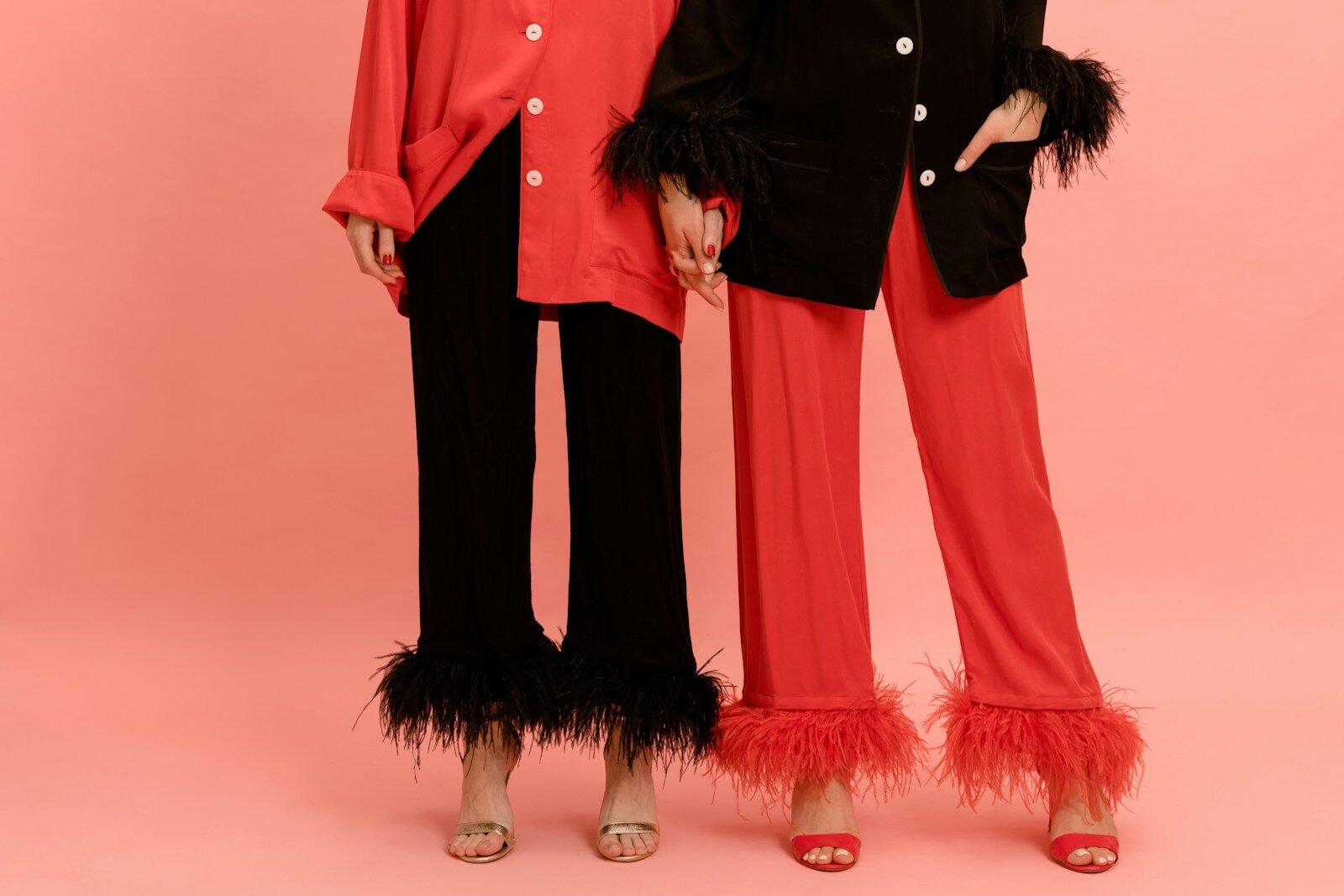two women standing next to each other in red and black outfits